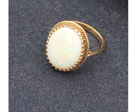 A 9ct yellow gold and opal ring, set oval cabochon precious white opal within wire work border, shank hallmarked. (gross weig