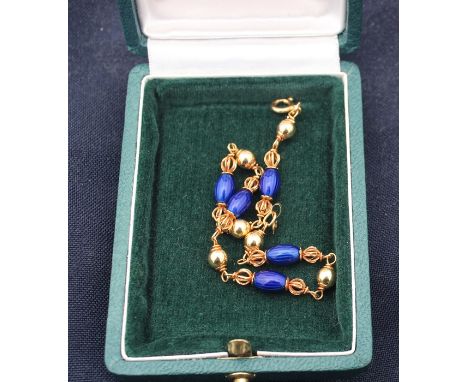 An 18ct. yellow gold blue enamel bracelet ,formed from alternating links of gold mounted deep blue enamel oval beads and sphe