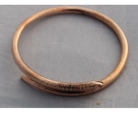 A 9ct. rose gold "serpent" slave bangle, fashioned as a coiled snake with open mouth with engraved eye and scale detail, diam