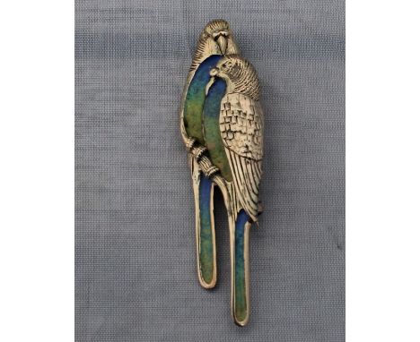A precious yellow metal and enamel budgerigar brooch, fashioned as a pair of budgerigars upon a branch, with finely engraved 