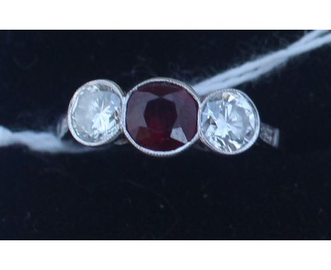 A white metal, diamond and ruby ring, set central round cut ruby with round brilliant cut diamond to either side and three sm