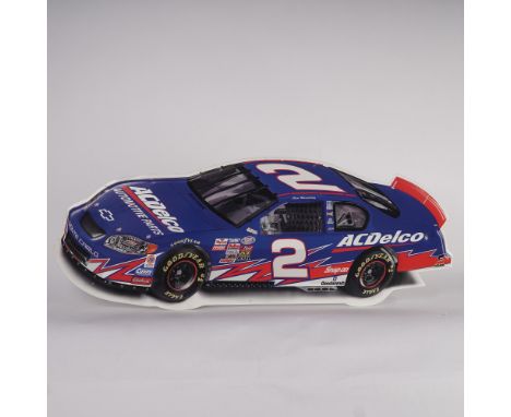Embossed die-cut advertising sign featuring a detailed image of a blue Chevrolet Monte Carlo SS NASCAR stock car sponsored by