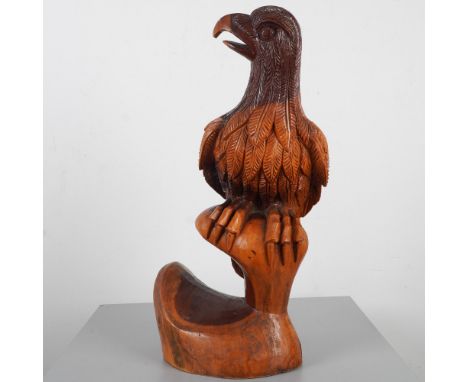 Impressive hand-carved wooden sculpture depicting a perched eagle with detailed feather and claw work throughout. Carved from