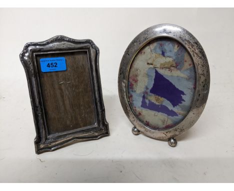 Two early 20th century silver photograph frames, one oval in shape standing on ball feet and easel back, stamped Sterling to 