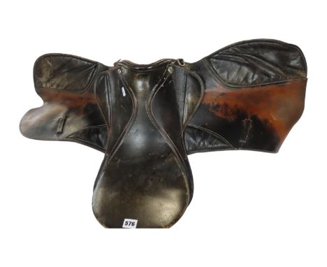 A vintage leather saddle and a stool 