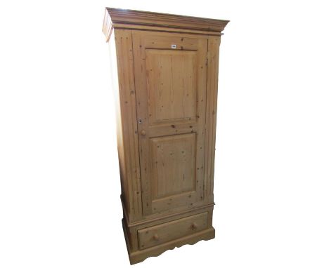 A contemporary pale pine bachelor’s wardrobe with hinged panelled door over a single drawer, 195 cm high x 90 x 53 cm