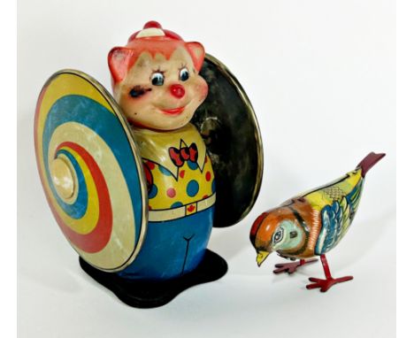 A vintage tin painted clockwork swirling clown with a plastic head, and a tin painted clockwork pecking bird.