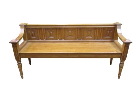 A Victorian pale oak hall bench with a shallow back with carved and panelled detail with swept arms on turned supports 73H x 
