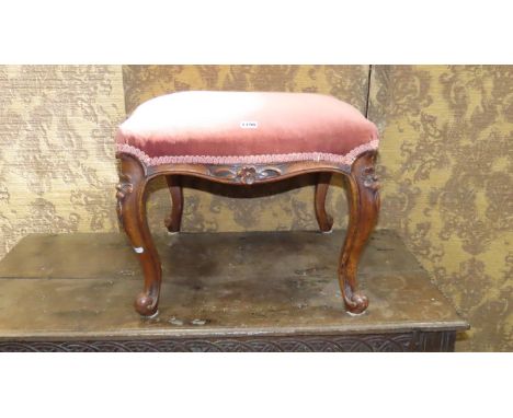 A Victorian serpentine walnut foot stool with upholstered cushion raised on floral carved cabriole legs, 45 cm high, 50 x 50 