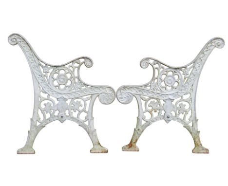 A pair of heavy gauge cast iron bench ends with painted finish and decorative pierced detail 