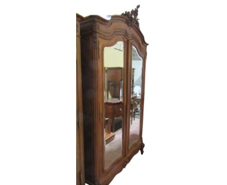 A French walnut single wardrobe with shaped outline enclosed by a pair of mirror plate doors of knockdown construction 250H x