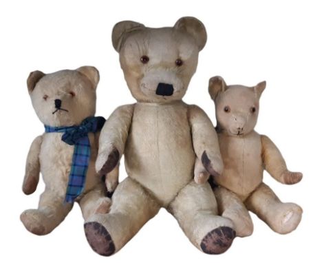 Three vintage teddy bears all with jointed body, glass eyes, stitched mouth and nose and original paw pads. Heights 62, 45 an