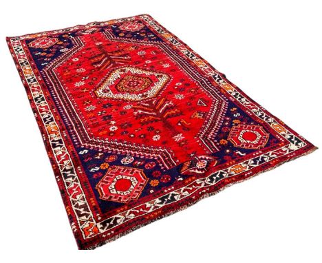 A south west Persian Lori rug, with an elongated diamond medallion on a red ground, 250cm x 150cm