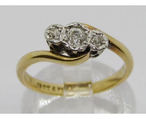 18ct platinum set three stone diamond crossover ring, size K/L, 3g