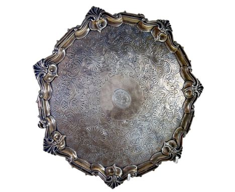 A silver salver with engraved scrolled decoration raised on three pad feet, London 1905, maker William Hutton &amp; Sons, 27 