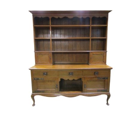 An Art &amp; Crafts oak dresser partially enclosed by an arrangement of cupboards and drawers with anodised fittings 218 cm x