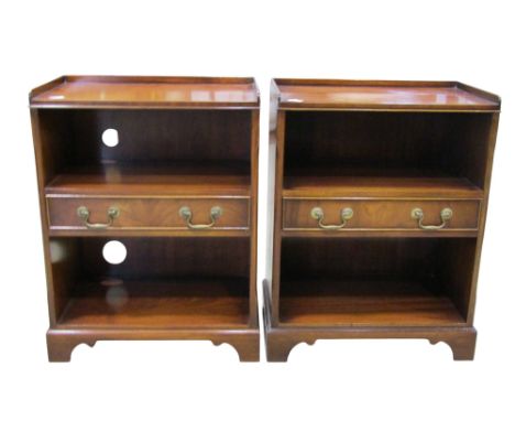 A pair of reproduction mahogany two-tier bedside/occasional tables with gallery tops, dividing drawers and bracket supports, 
