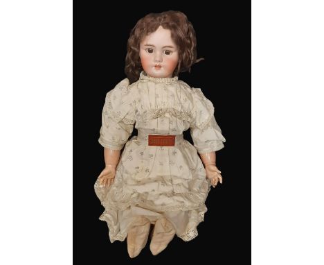 Early 20th century bisque head doll wearing a Bebe Jumeau dress of printed cotton trimmed with lace. Doll has  impressed mark