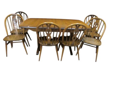 An Ercol elm extending refectory table on stretcher base, together with a set of Ercol hoop back dining chairs with fleur de 