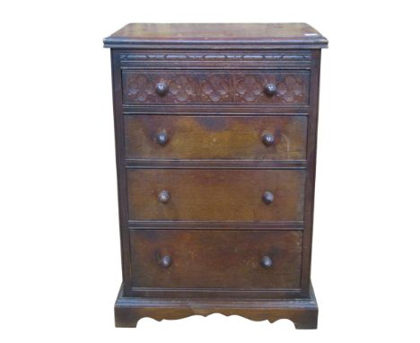 A small continental oak chest of four drawers with carved detail, acorn handles and bracket supports, 70 cm high, 48 x 31 cm