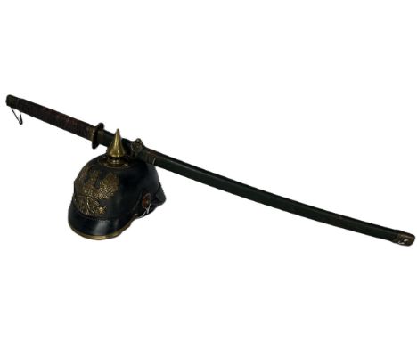 A WII German Imperial Army Picklehaub helmet together with a Japanese sword with a leather bound grip in a green metal scabba
