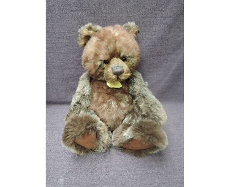 A Charlie Bears Jointed Teddy bear named Chester having plastic eyes, stitched nose and mouth, two tone brown plush body and 