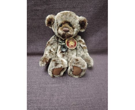 A Charlie Bears Jointed Teddy bear named Jooles having plastic eyes, stitched nose and mouth, two tone brown plush body and h