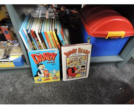 A shelf containing 17 Beano, Dandy, Beezer and simalar Annuals including 1983 Dandy, 1984 Beano, 1989 Beezer with plastic sto