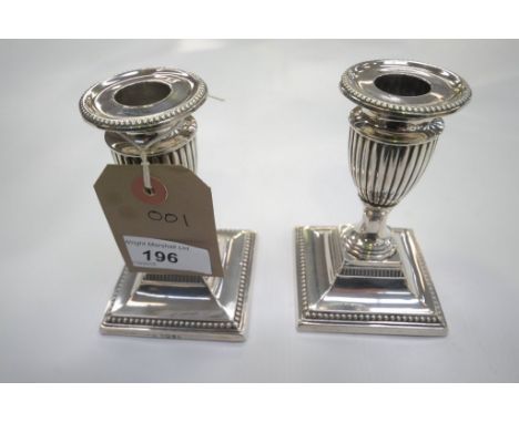 A Pair of weighted silver vase shaped desk candlesticks with beaded square plinths, Sheffield 1888. 