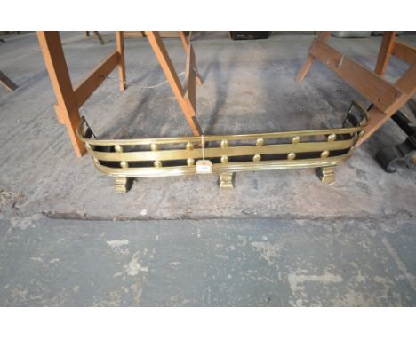 A George IV brass fender
Of bowfront outline with a plain rail embraced by roundels raised upon three bracket feet. 98cms.