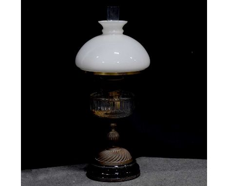 Victorian brass and glass oil lamp, facet cut clear glass reservoir supported on a fluted knopped pedestal, black ceramic cir