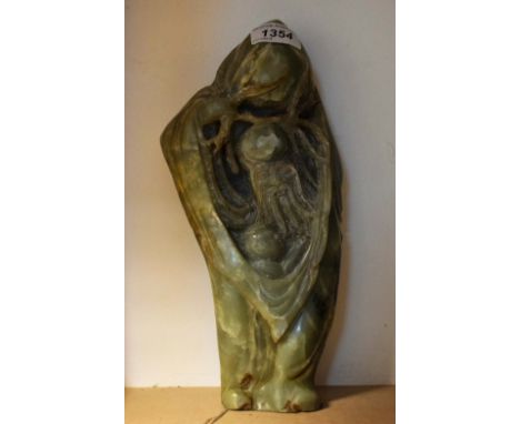 A 19th century Chinese russet jade carving, of Shou Lao, holding a giant peach, a child under his robe, 28cm high