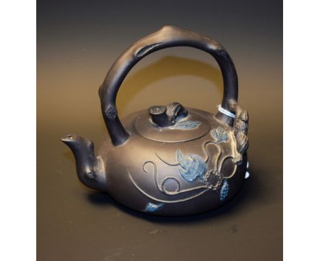 A Chinese Yixing Duan Ni tea kettle, of small proportions, moulded in high relief with scrolling leafy stems, arched branch h