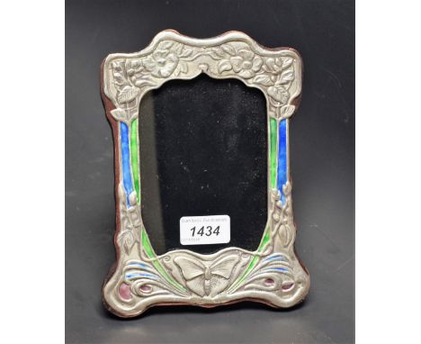 An Art Nouveau style embossed white metal frame, enamel style decoration