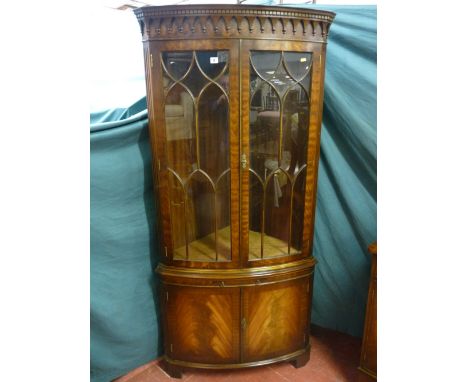 A quality reproduction mahogany double door corner cabinet with arched gallery top frieze, ten pane upper doors with arched m