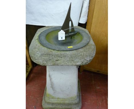 A reconstituted stoneware garden plinth with dished metal sundial/bird bath with yacht indicator, Roman numerals and the word