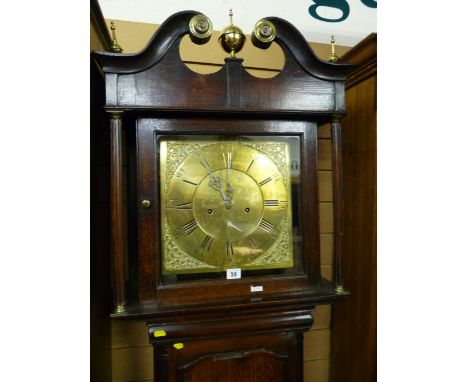 An 18th Century oak longcase clock, the square hood having a scrolled pediment with brass finials, narrow turned Corinthian c