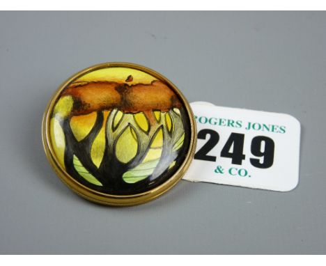 A Moorcroft enamel brooch with stylized tree patterns in a gilt metal frame with clip, marked 'Moorcroft '05, Made in England