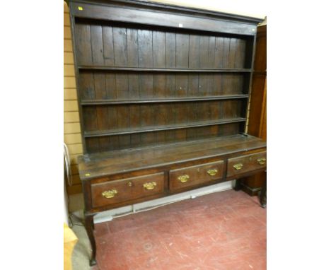 A George II and later Shropshire oak dresser, the tall closed back three shelf rack on a plank top base with three frieze dra