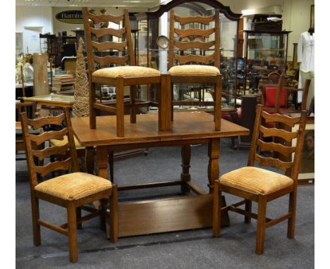 A 1930's country oak extending dining table; four oak ladder back chairs (5)