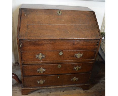 An Oak bureau of three long drawers on bracket feet