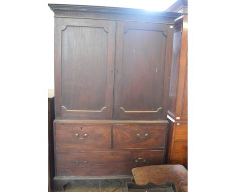 A Mahogany linen press with dental moulding to cornice above a blind frieze and panelled doors over two short and one long dr