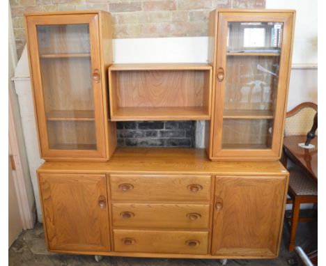 A light Ercol glazed unit, consisting of a three drawer sideboard, two glazed cupboards and open shelf unit