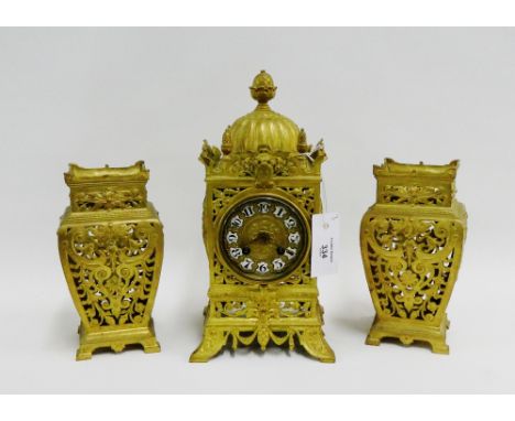 French gilt brass clock garniture, the mantle clock with domed top and acorn finial above enamelled Arabic numerals, the move