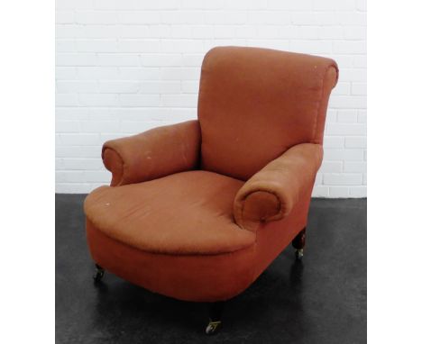 Victorian upholstered armchair on wooden supports with brass caps and ceramic castors, 
