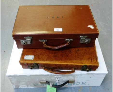 Two vintage brown leather cases and a vintage white storage tin, (3)
