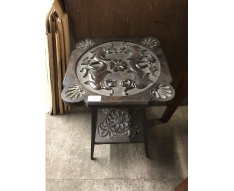 An early 20th Century Arts and Crafts carved oak lamp / plant stand