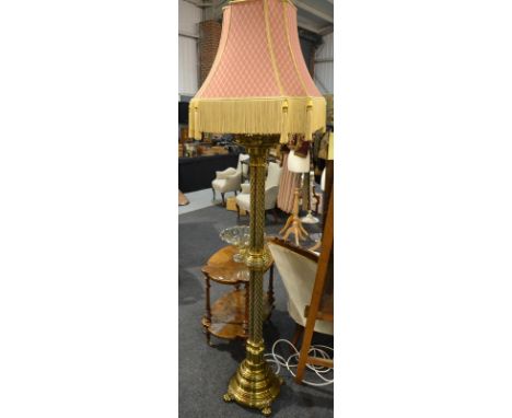 A brass ecclesiastical style standard lamp, with a pierced gallery and script motto to the central band, raised to four colum