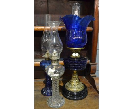 A Victorian brass oil lamp with blue shade and reservoir and two similar smaller oil lamps (3)