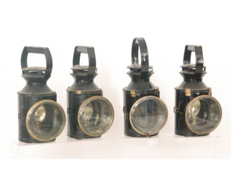 A black painted railway lamp with bulls eye lens and four similar hand lamps, A/F (5)